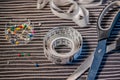 Tape measure, dress making pins and scissors on a background of stripey material Royalty Free Stock Photo