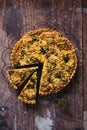 Top down view of a delicious broccoli quiche on wooden table, with piece cut out Royalty Free Stock Photo