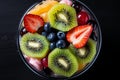 Top down view of a delicious and vibrant fruit salad in a glass bowl on a wooden table