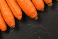 Top down view, detail of carrots on black board, space for text in down right corner