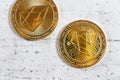 Top down view, detail of golden commemorative EOS - EOSIO cryptocurrency - coins on white stone board