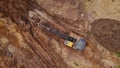 Top down view of an excavator working on the construction site on red soil Royalty Free Stock Photo