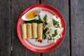 Top down view of four Thai springrolls on a traditional plate