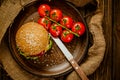 Top down view of fresh beef burger on rustic wooden serving table with knife. Homemade cooking Royalty Free Stock Photo