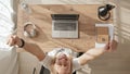Top down view of girl working at computer, achieving success and joy. young woman throws her hands up in win or