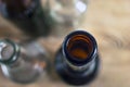 Top-Down View of Glass Bottle Rim, Bore, Orifice or Throat. Blurred Empty Glass Bottles, Wooden Background. Healthy Living and