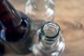 Top-Down View of Glass Bottle Rim, Bore, Orifice or Throat. Blurred Empty Glass Bottles, Wooden Background. Healthy Living and