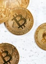 Top down view, golden commemorative btc - bitcoin cryptocurrency - coins scattered on white stone board, closeup detail