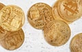 Top down view, golden commemorative btc - bitcoin cryptocurrency - coins scattered on white stone board, closeup detail