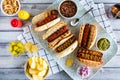 A top down view of gourmet hotdogs surrounded by all the fixings.