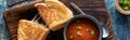 Top down view of a grilled cheese sandwich served with a bowl of tomato soup, ready for eating. Royalty Free Stock Photo