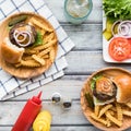 Top down view of hamburger sliders on small plates served with french fries. Royalty Free Stock Photo
