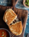 Top down view of a homemade grilled cheese sandwich on a wooden board, served with tomato soup. Royalty Free Stock Photo