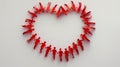 Top-down view of interconnected red paper cutout people forming a heart shape, holding hands Royalty Free Stock Photo