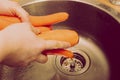 Top down view on metal sink in a modern kitchen with hands washing vegetables. old, vintage, retro style Royalty Free Stock Photo