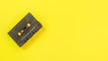 Top down view, old audio tape in cassette on yellow board, space for text on right side