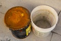 Top-down view of an old rusty metal bucket and a dirty white plastic bucket, closeup Royalty Free Stock Photo