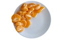 Top down view of pealed mandarin peaces on white plate on white background