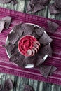 Top down view of a platter of blue corn chips with a bowl of beetroot hummus in the middle.