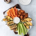 Top down view of a platter filled with finger food appetizers including jalapeno poppers and chicken wings. Royalty Free Stock Photo