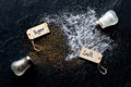 Top down view of salt and pepper shakers tipped over and salt and pepper spilled out onto black slate. Royalty Free Stock Photo