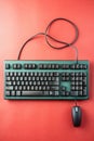 Teal Mechanical Keyboard and Black Mouse on Red Background computer technology Royalty Free Stock Photo