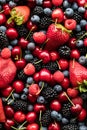 A top down view of a variety of berries and cherries in a pile.