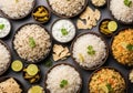 Assortment of delicious Indian rice dishes, including biryani, pulao, and plain basmati, served with raita, pickles, and papadums Royalty Free Stock Photo