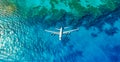 Top down view of white plane flying over blue sea, ocean, travel, vacation concept - AI generated image Royalty Free Stock Photo