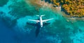 Top down view of white plane flying over blue sea, ocean, travel, vacation concept - AI generated image Royalty Free Stock Photo