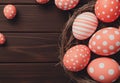 A top-down view of a wooden background featuring a nest of red and white Easter eggs, sun rays, and ample copy space Royalty Free Stock Photo