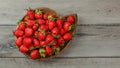 Top down view, wooden carved bowl full of strawberries