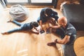 Top down view young family playing on the wooden floors in the living room, little girl lying on the floor Royalty Free Stock Photo