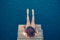 Beautiful female sitting on small wooden dock