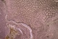 Cracked dry soil on the river or lake bed with a tiny stream of flowing water. Climate change concept. Royalty Free Stock Photo