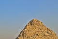 The top of the Egyptian pyramid against the blue sky. Royalty Free Stock Photo