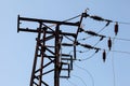 Top of electrical transformer pylon, photo of electric wires against blue sky. Royalty Free Stock Photo