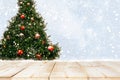 Top of empty wood table with beautiful Christmas tree and snowfall  backdrop Royalty Free Stock Photo