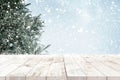 Top of empty wood table with fir tree and snowfall  backdrop. Royalty Free Stock Photo