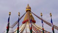 Top of Boudhanath stupa in the center of Kathmandu, Nepal, decorated with Buddhist prayer flags and five flagposts. Royalty Free Stock Photo