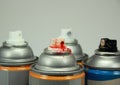 Top of four isolated spray cans with different colors