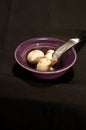 Purple, ceramic bowl with three white mushrooms Royalty Free Stock Photo