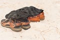 Two pair of leather sandals and black shirt, left in the tropica Royalty Free Stock Photo