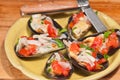 Yellow, round bowl of steamed mussels on half shell with onion, tomato, garlic Royalty Free Stock Photo