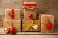 Top front view of Gift boxes on vintage wooden background. Presents in craft paper decorated with red gold ribbon bows Royalty Free Stock Photo