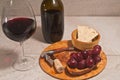 glass of red wine, bottle of wine, corkscrew, cork, rare wood bowl of red grapes