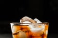 Top of glass with coke and ice on black background