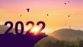 2022 at top of grass mountain with birds flying on sunset sky abstract background. Happy new year and freedom concept Royalty Free Stock Photo