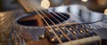 The top of a guitars sound hole with the strings visible and a small piezoelectric pickup attached for amplification