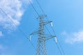 Top of a high voltage pylon seen from below against a blue sky with some clouds Royalty Free Stock Photo